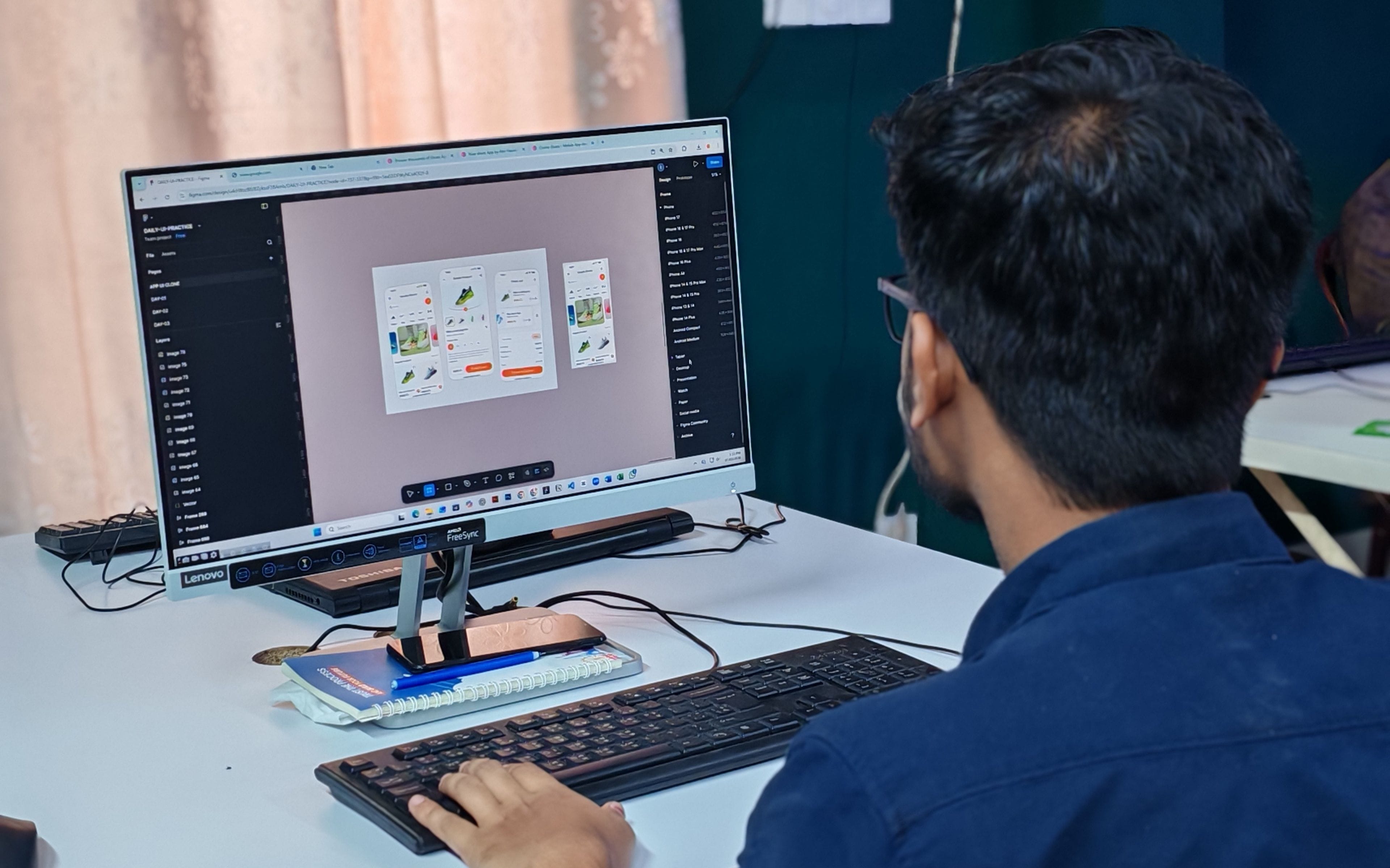 Designer working on an application interface layout at a desktop monitor