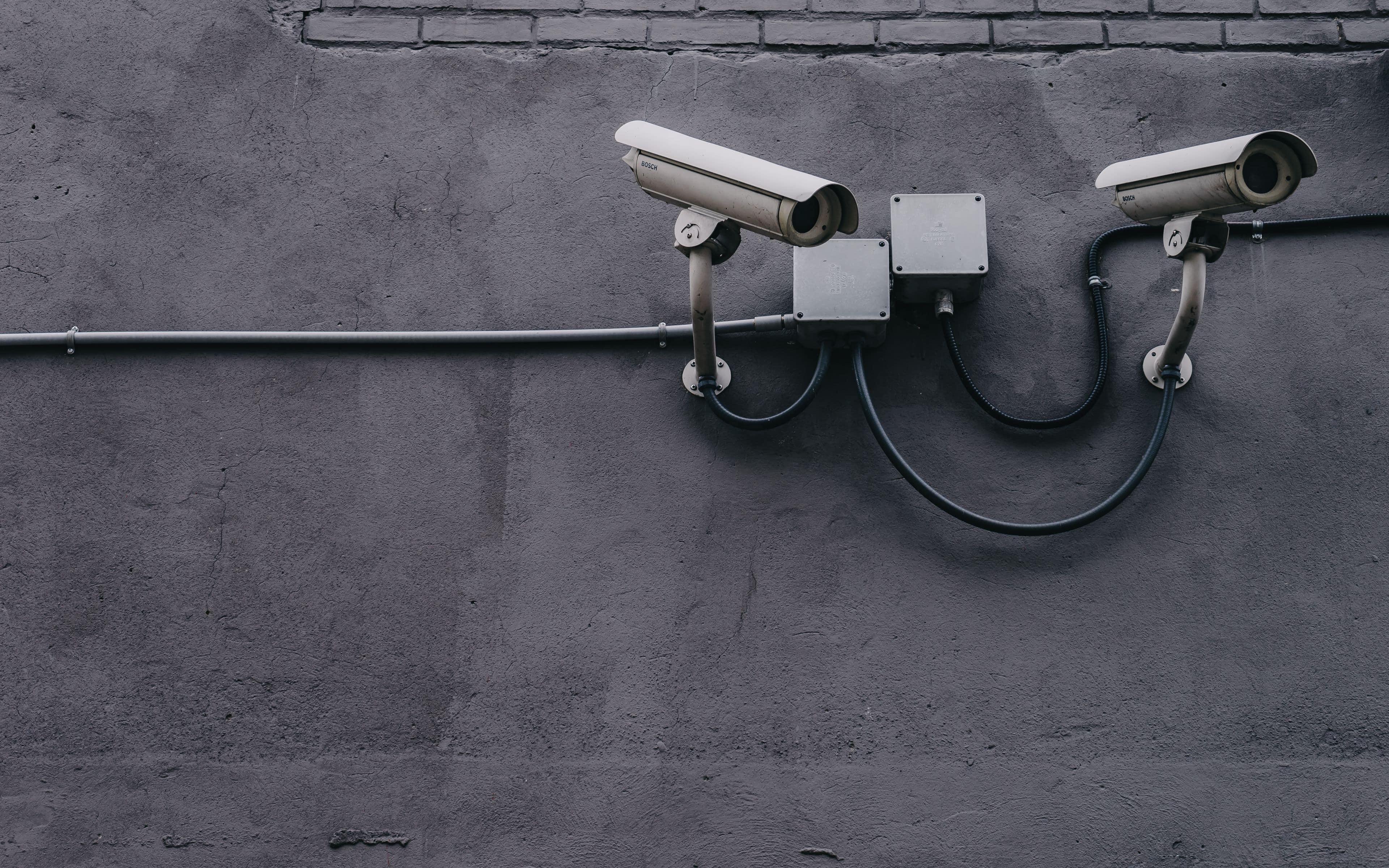 Pair of security cameras mounted on a wall to monitor the area