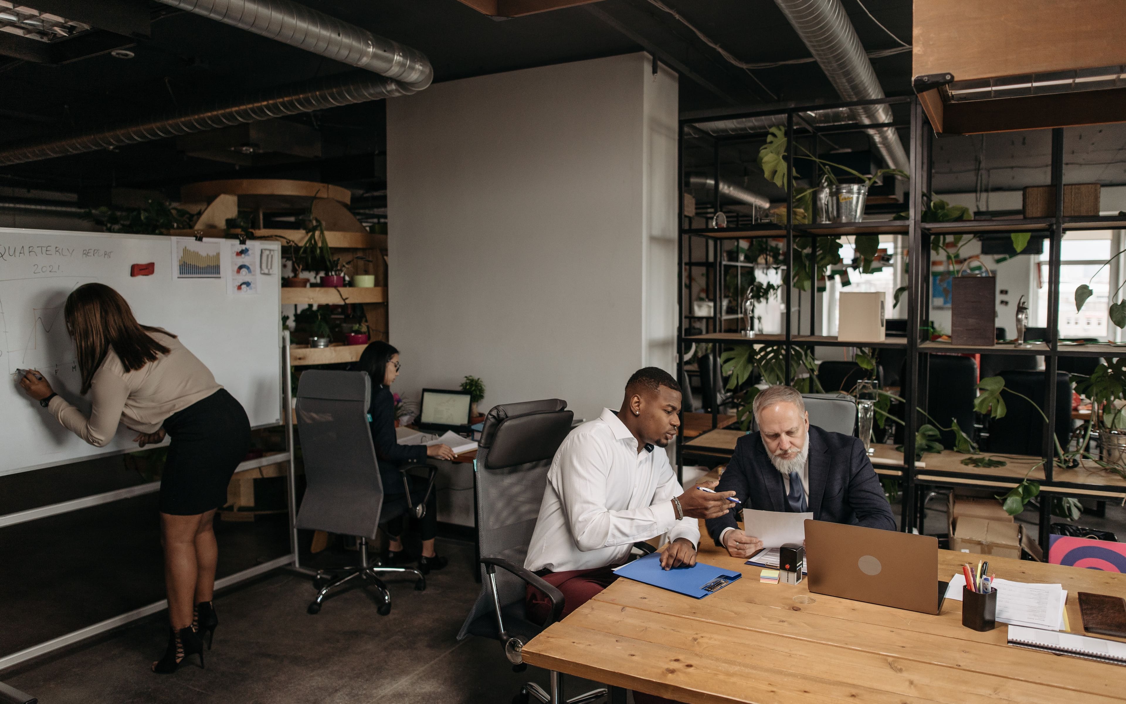 Open-plan office with staff working across desks and meeting areas