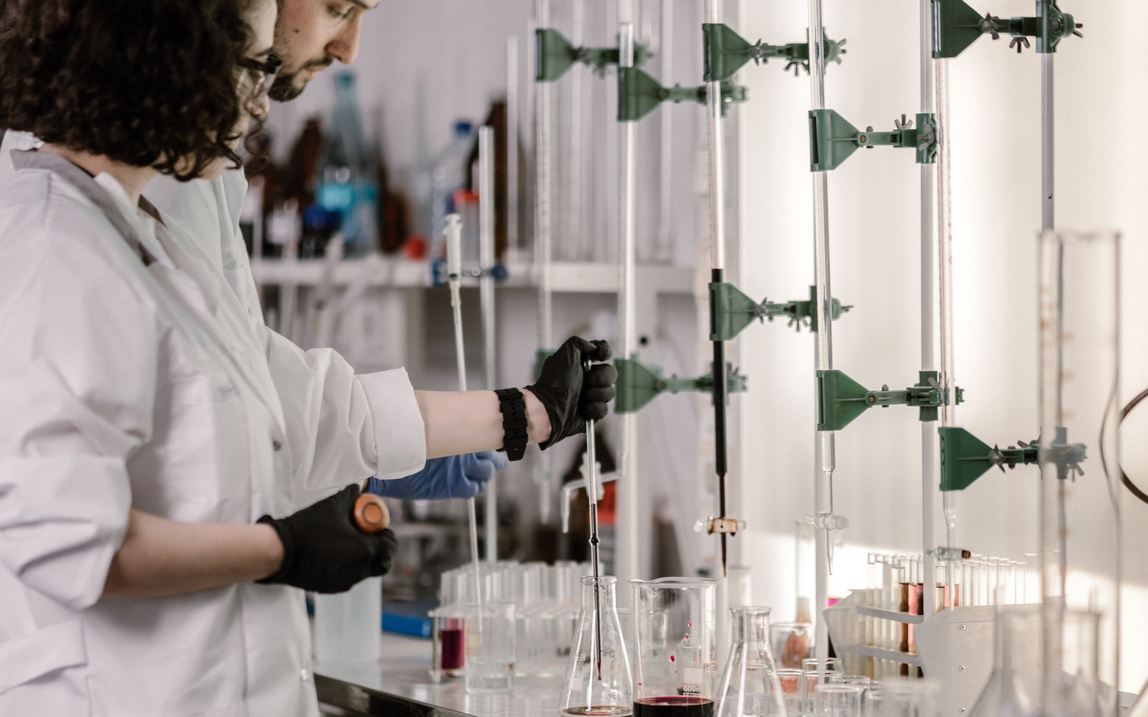 Researcher running a laboratory analysis with glassware and lab equipment